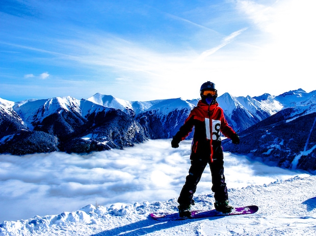 Teen snowboarding above the clouds for Never Ever Days Alberta