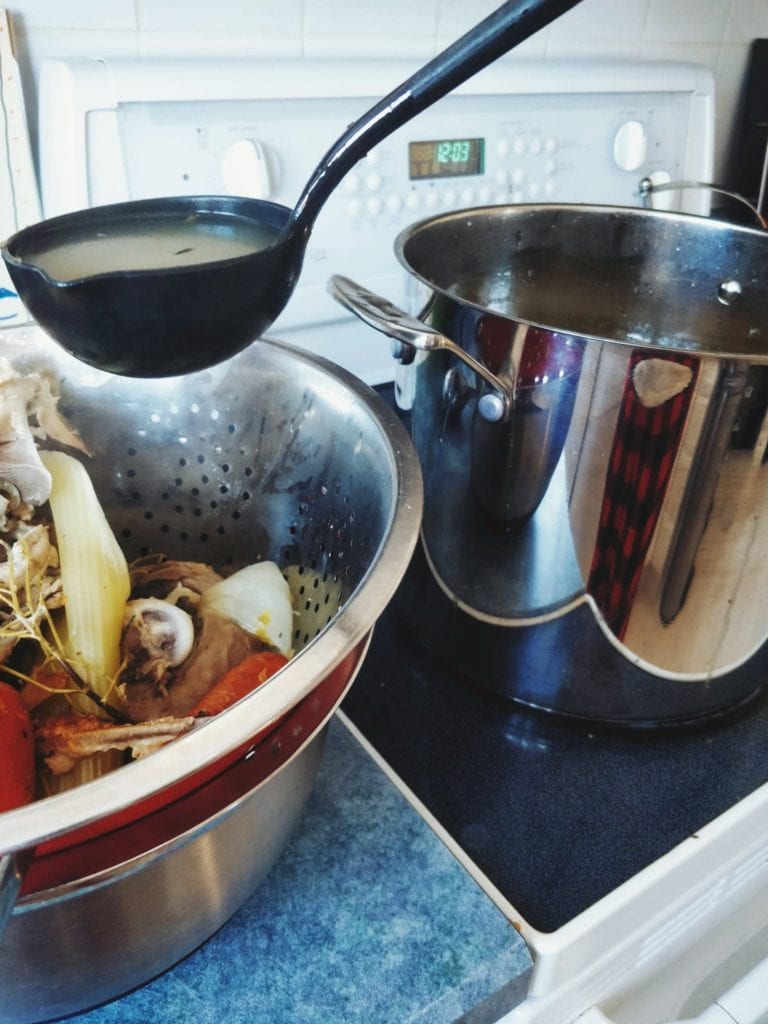 Home made bone broth being strained