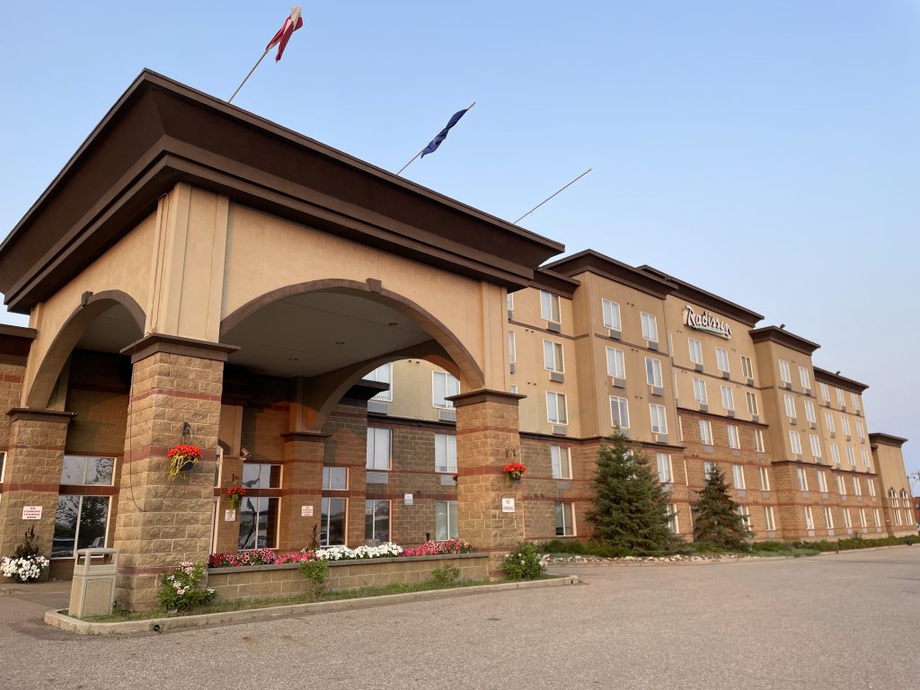 Exterior of the Radisson Hotel and Suites Fort McMurray - a beige, 5 story building.