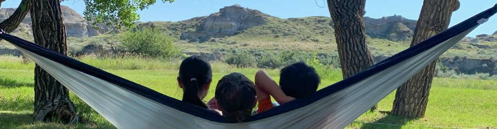 Mom and kids sitting in hammock in Dinosaur Provincial Park
