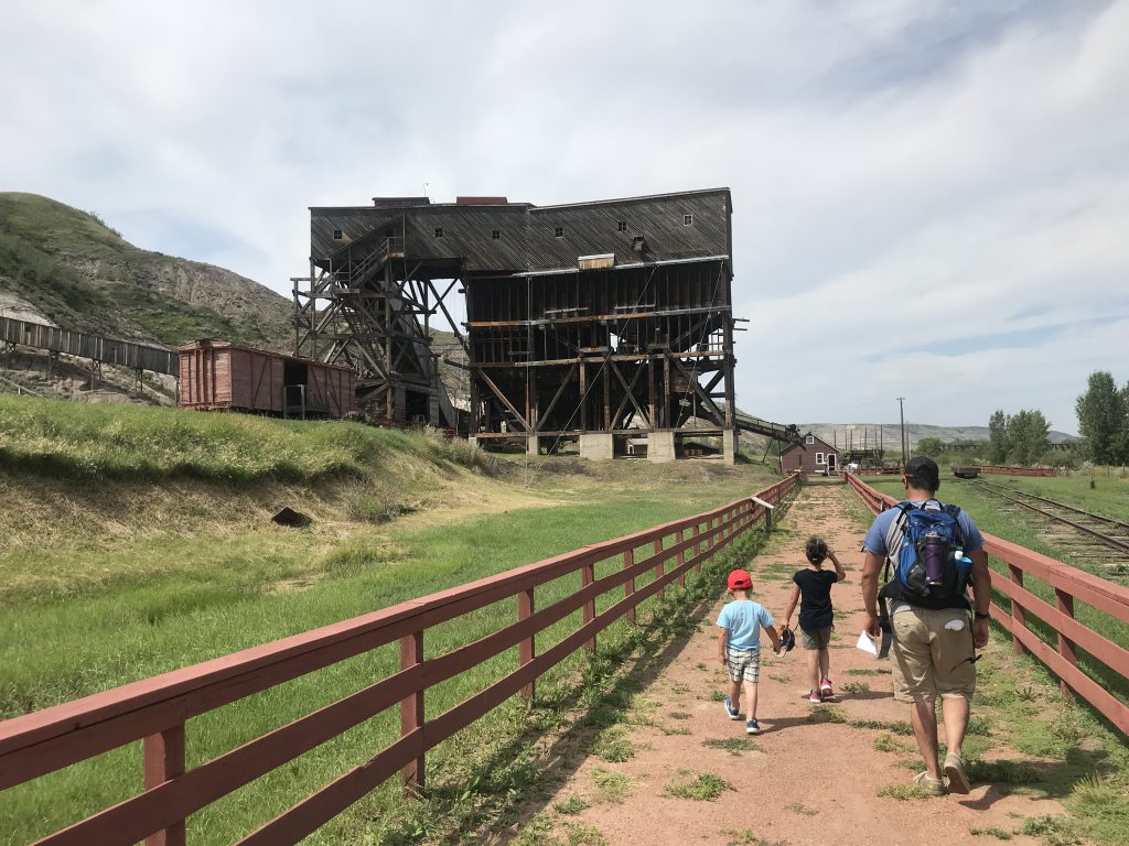 Kids and Dad walking towards the Tipple along a red fence lined path at Atlas Coal Mine