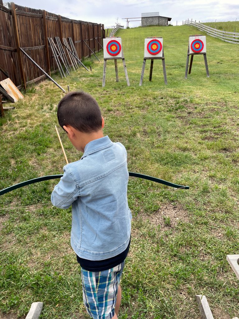 Seven year old learning to shoot a bow for the first time. Archery lessons at Good Knights.