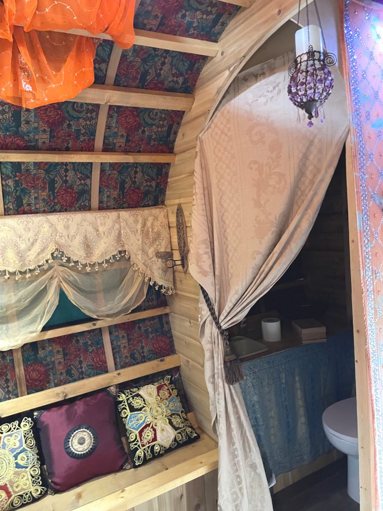 Good Knights caravan interior. Seating, fabric covered ceiling, and bathroom.
