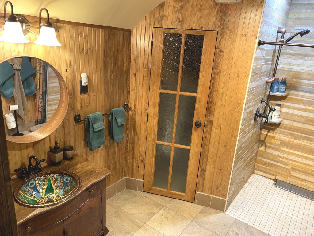 Bathroom sink, storage, and shower in The Burrow