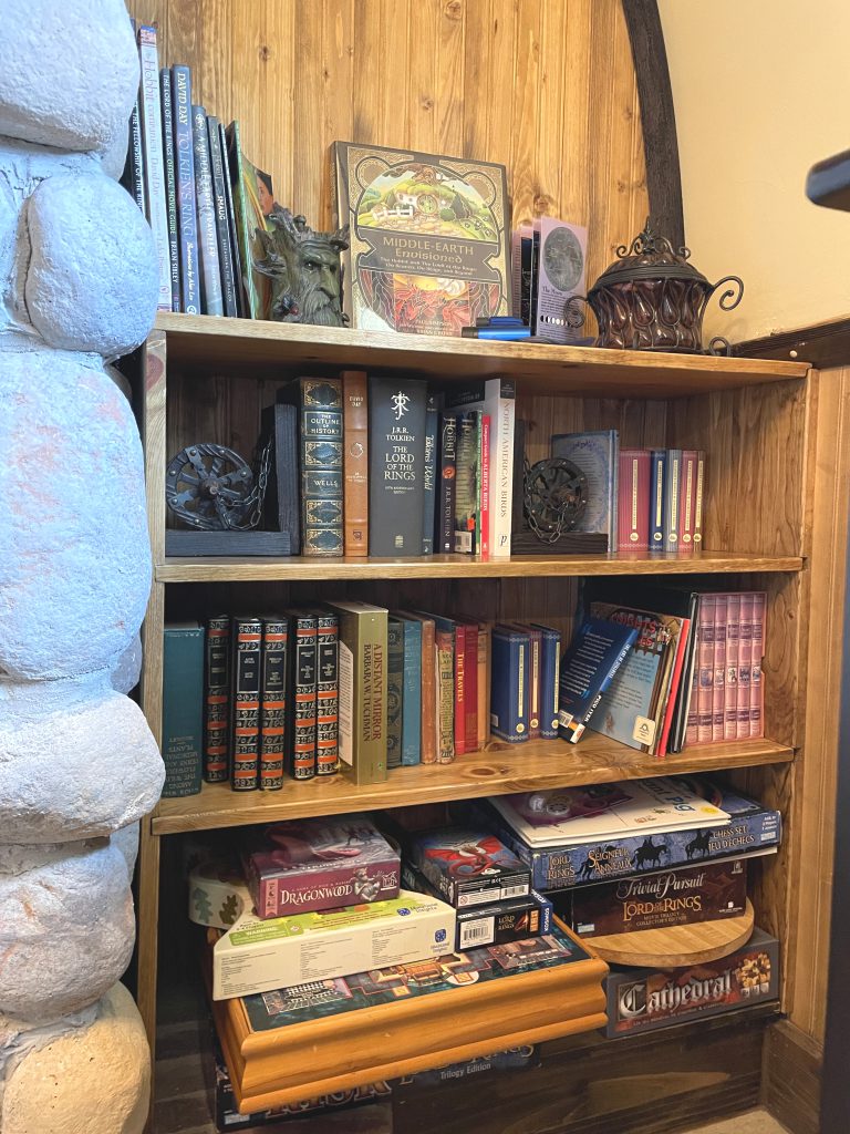 Bookcase filled with Tolkien and bird books, plus a shelf of board games.