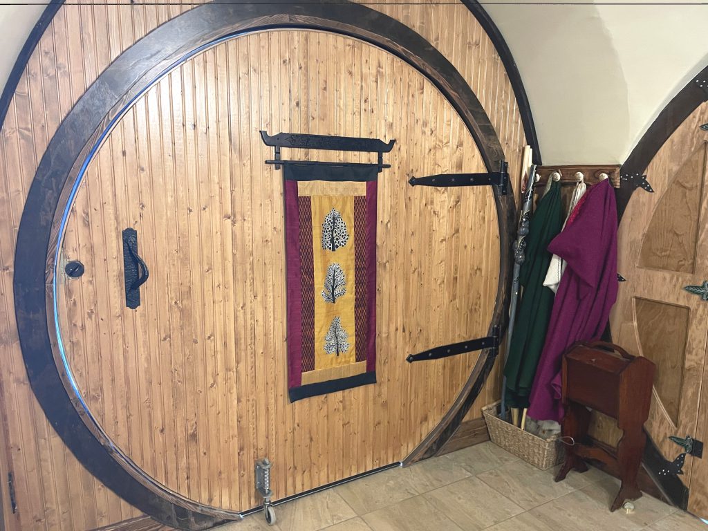 Large round door and cloak rack in the interior of The Burrow entrance.