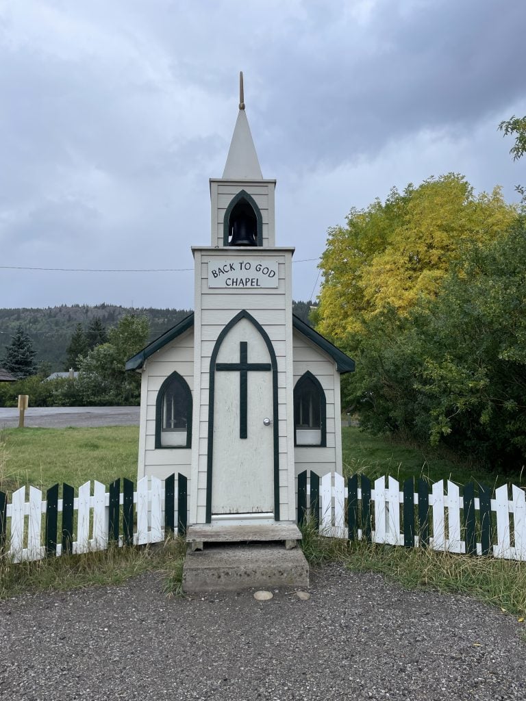 Front view of the white with black trip Back to God Chapel tiny church in Blairmore.